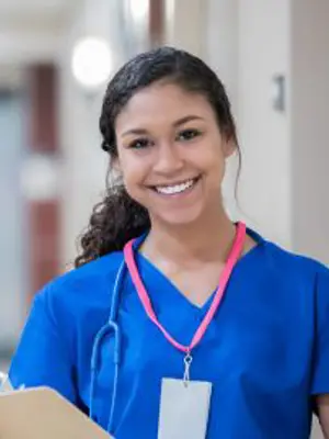 A medical student smiling, holding chart