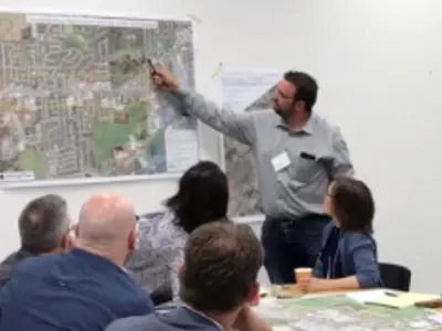 A group of people at a meeting looking at a map