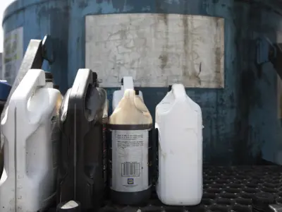 Jugs of hazardous liquid are placed on a shelf at the depot for safe disposal